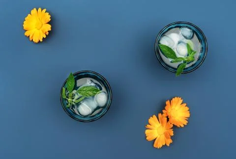 Two beautiful vintage blue glasses with cold drink and ice cubes, with fresh Stock Photos