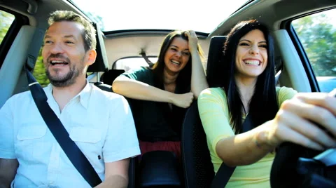 Two beautiful women and one handsome man having fun driving car happy Stock Footage 40386653