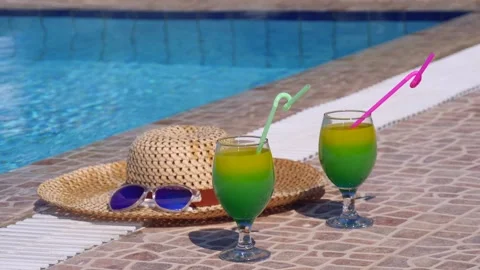 Two beautiful yellow-green-orange cocktails with straws, sunglasses and straw Stock Footage 130517672