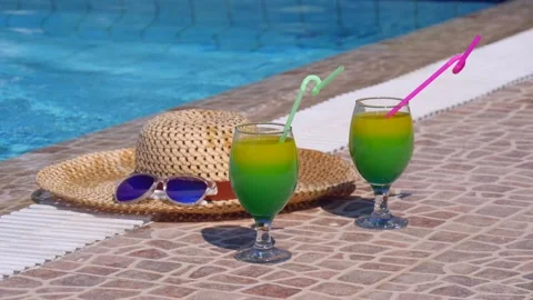 Two beautiful yellow-green-orange cocktails with straws, sunglasses and straw Stock Footage 130526454