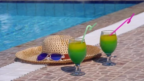 Two beautiful yellow-green-orange cocktails with straws, sunglasses and straw Stock Footage 130529210
