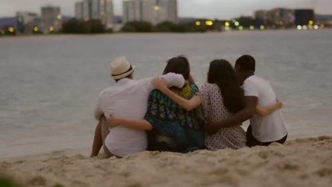 Two beautiful young couples cuddling on the beach, looking at the horizon at sun Stock Footage 199459710