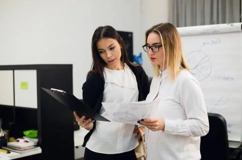 Two beautiful young executives reading some papers Stock Photos
