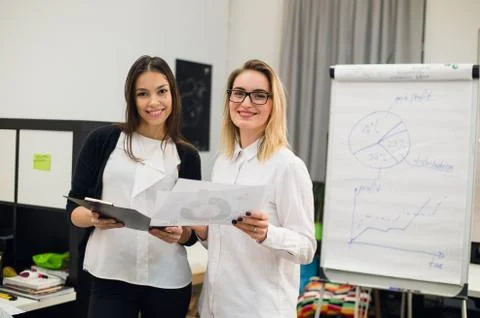 Two beautiful young executives reading some papers Stock Photos