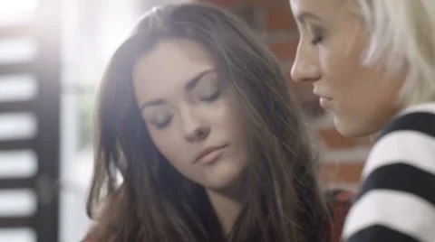 Two beautiful young girls studying at modern loft apartment. Stock Footage