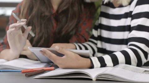 Two beautiful young girls studying at modern loft apartment. Stock Footage