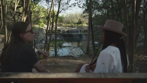 Two Beautiful Young White and Black Women Having a Conversation in a Park Stock-Footage 151434255