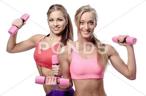 Two beautiful young women doing fitness exercise with dumbbells Stock Photos