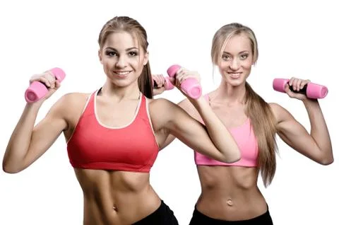 Two beautiful young women doing fitness exercise with dumbbells Stock Photos
