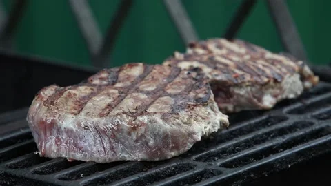 Two beef steaks are grilled on a cast iron grill Stock Footage 90020115
