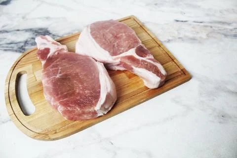 Two beef steaks on a tray top view on a light background. Cooking beef Stock Photos