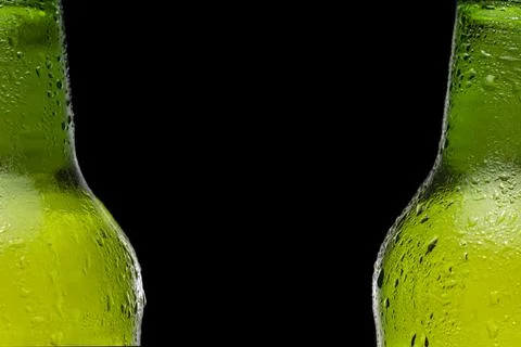 Two beer bottles in a row on black background. Drops on the bottle. Cold and Stock Photos