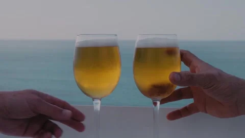 Two Beer Glasses Toasting on Sea View Balcony Stock Footage 346022304