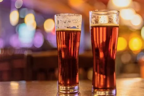 Two beer pints on bar counter at night Stock Photos