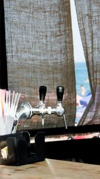 Two beer taps in focus on a blurred background at sea Stock Photos