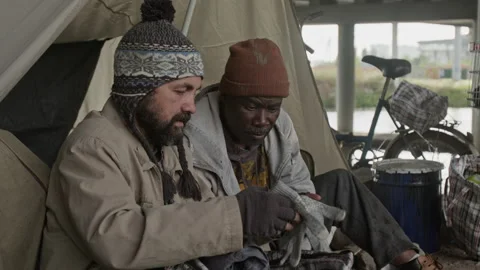 Two Beggars Finding Gloves in Plaid Bag, African American Man Putting Them on Stock Footage 317310093