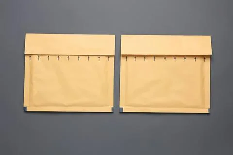 Two beige paper envelopes with flaps on gray background Stock Photos