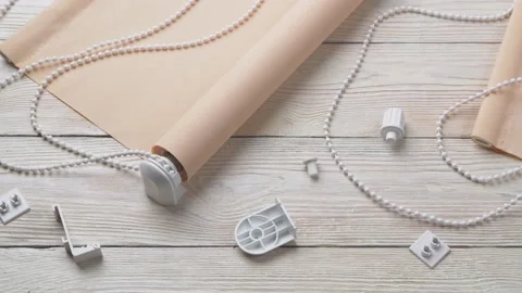 The two beige roller blinds and spare parts on a white wooden table Stock-Footage 147948556
