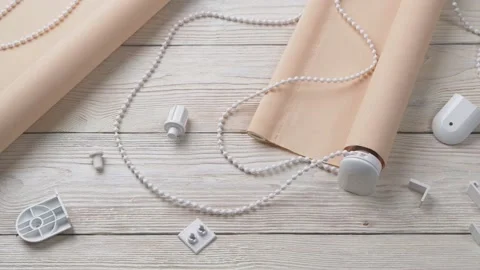 The two beige roller blinds and spare parts on a white wooden table Stock Footage 147948568
