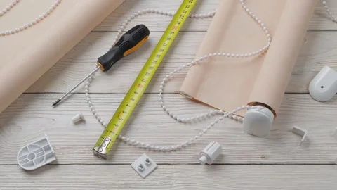 The two beige roller blinds, spare parts, mesure tape and screwdriver Stock-Footage 147948487
