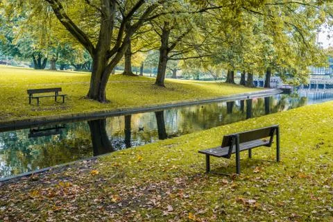 Two benches in a park with a small stream Stock Photos
