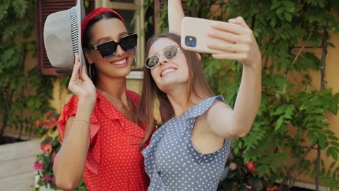 Two best friends have fun, laugh, take selfies on background of beautiful house Stock Footage 138077177
