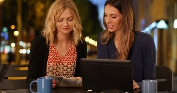 Two best friends using travel map in Champs Elysees in Paris, France Stock Footage 86016579