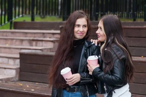 Two best friends, young brunette women with long hair, stand in park in autum Stock Photos