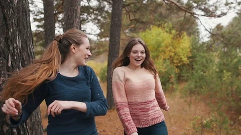 Two beutiful girls dancing in the autumn forest and have fun. Stock Footage 69764374
