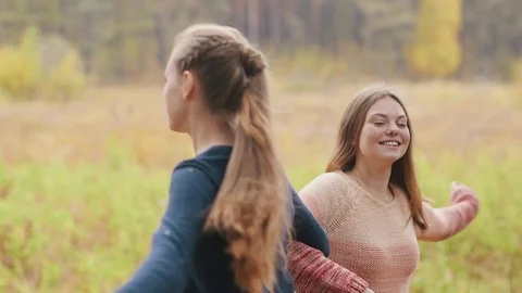 Two beutiful girls dancing. They laughing and spin around Stock Footage 69764593