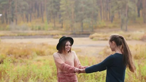 Two beutiful girls dancing. They laughing and spin around Stock Footage 69764642