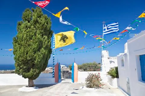 Two big and lots of small flags in a churchyard in Oia, Santorini. Stock Photos