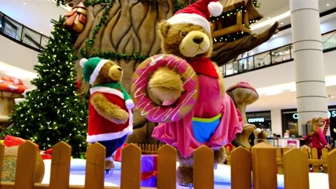 Two big artificial bear dolls dressed in Santa suites skating. in shopping mall 스톡 동영상 132923120