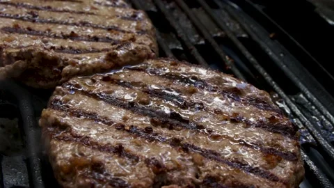 Two big bio meat burger patios grilling on an electric bbq grill with smoke c Stock Footage 131320316