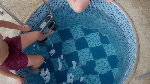 Two big boys jump into a small cold pool to win a coin Stock-Footage 119801546