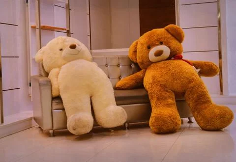 Two big teddy bears on a couch Stock Photos