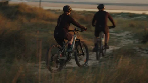 Two bikers arrive on beach at sunset Stock Footage 308877275