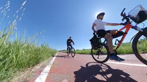 Two Bikers on bicycle lane a spring sunny morning Stock Footage 133464778