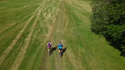 Two bikers crossing field Stock Footage 247848724