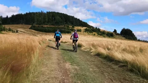 Two bikers crossing high grass field Stock Footage 247848723