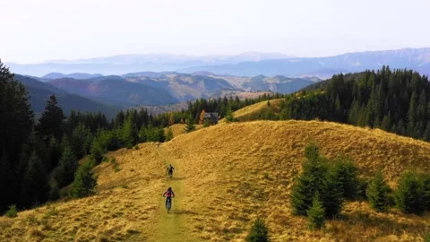 Two bikers riding down a mountain trail in autumn sunny day. 스톡 동영상 150555054