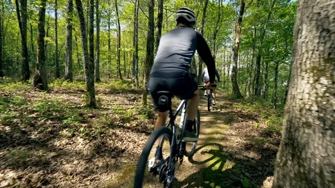 Two Bikers Riding Through Forest Trails, Low Close-up of Bike Stock Footage 95947555