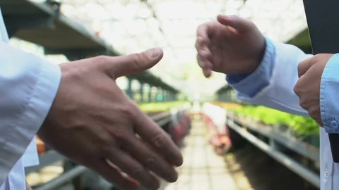 Two biology experts in uniform shaking hands, agricultural business agreement Stock Footage 118913082