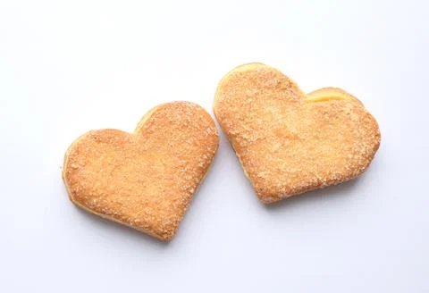 Two biscuits in sugar in the shape of a heart on a white background. Valentin Stock Photos