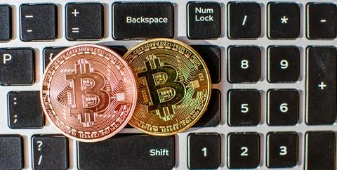 Two bitcoin placed on a laptop computer keyboard in the daytime. concept di.. Stock Photos