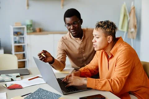 Two Black Business People Using Laptop in Office Stock Photos