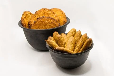 Two black ceramic bowls with cookies on a white background Stock Photos