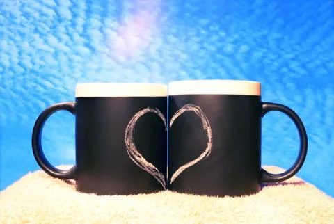Two black circles with a symbol of love against the blue sky. Heart drawn in  Stock Photos