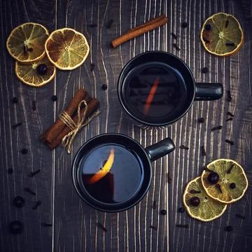 Two black cups of tea with lemon on a dark background. lemon slices, cinnamon Stock Photos