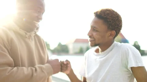 Two black friends, two African American students greet each other with their Stock Footage 137116257